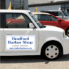 magnetic car sign on car door showing company name, logo and contact details