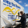 Customer applying air-escape vinyl to a removals van
